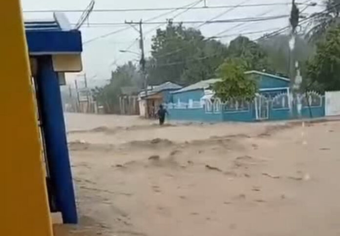 Las imágenes devastadoras muestran cómo el agua arropa viviendas y otras infraestructuras de la comunidad, con una fuerte corriente.