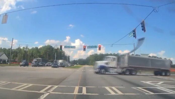 La cámara de un auto grabó el momento en que la estructura de cables se enganchó en el techo del tráiler, provocando fallos viales y caos vehicular.