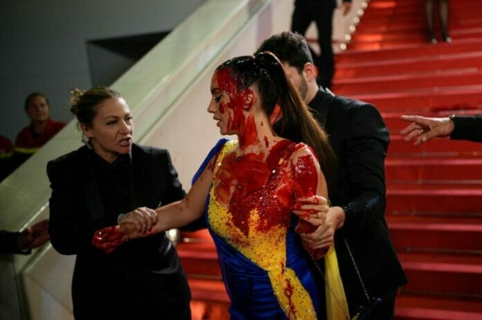 Mujer se rocía sangre falsa en protesta por la guerra en Ucrania en Cannes