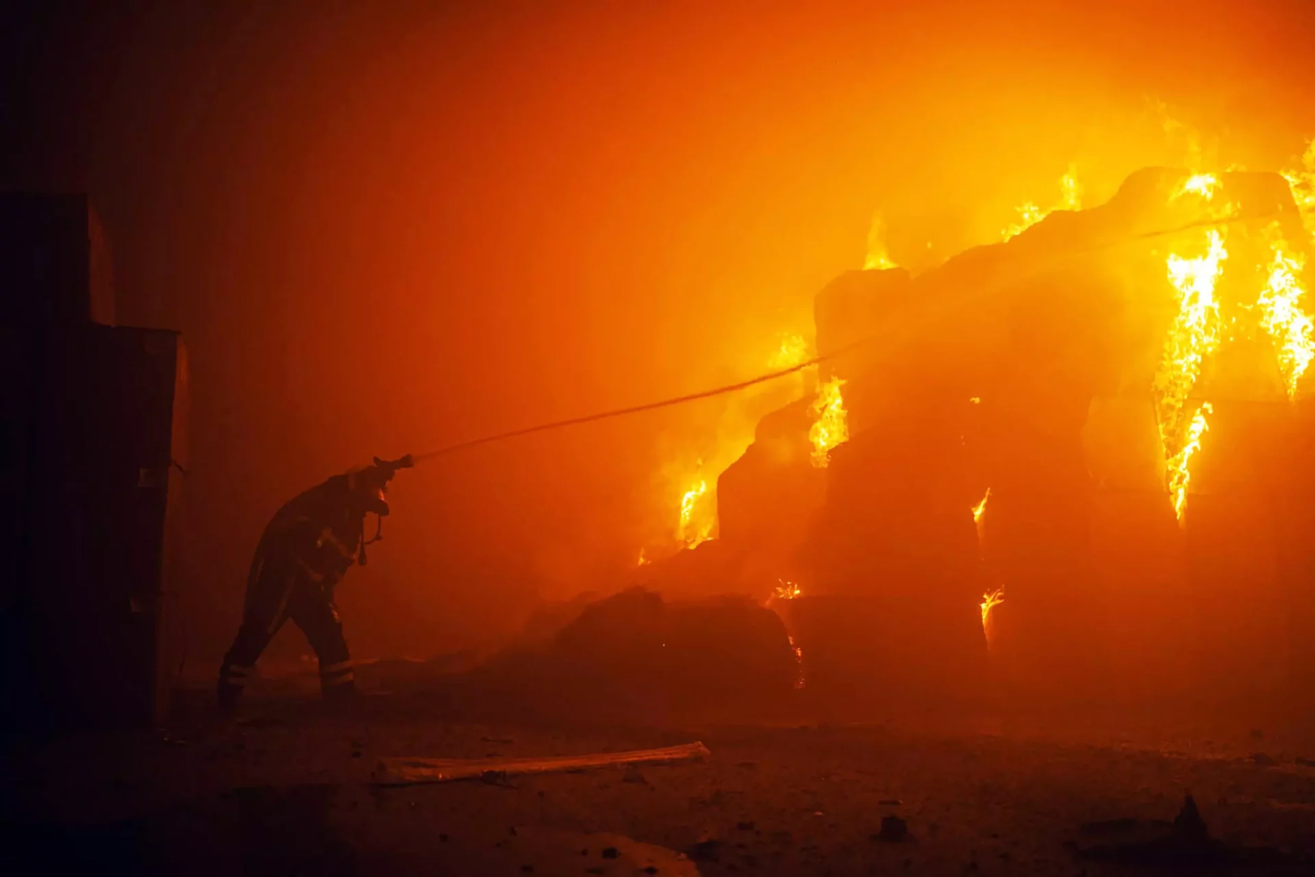 El Servicio Estatal de Emergencias de Ucrania acude a un edificio para apagar un incendio causado por la caída de escombros después de un ataque masivo con drones rusos.