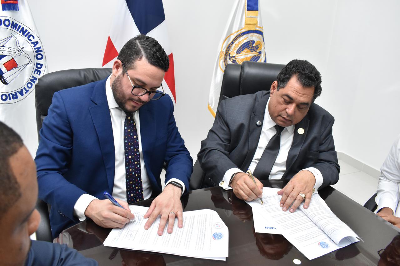 El presidente del Colegio de Notarios, Jhon Richard Feliz Paniagua y el presidente de ADOMA, Paul José Maldonado Bueno, firman el acuerdo.