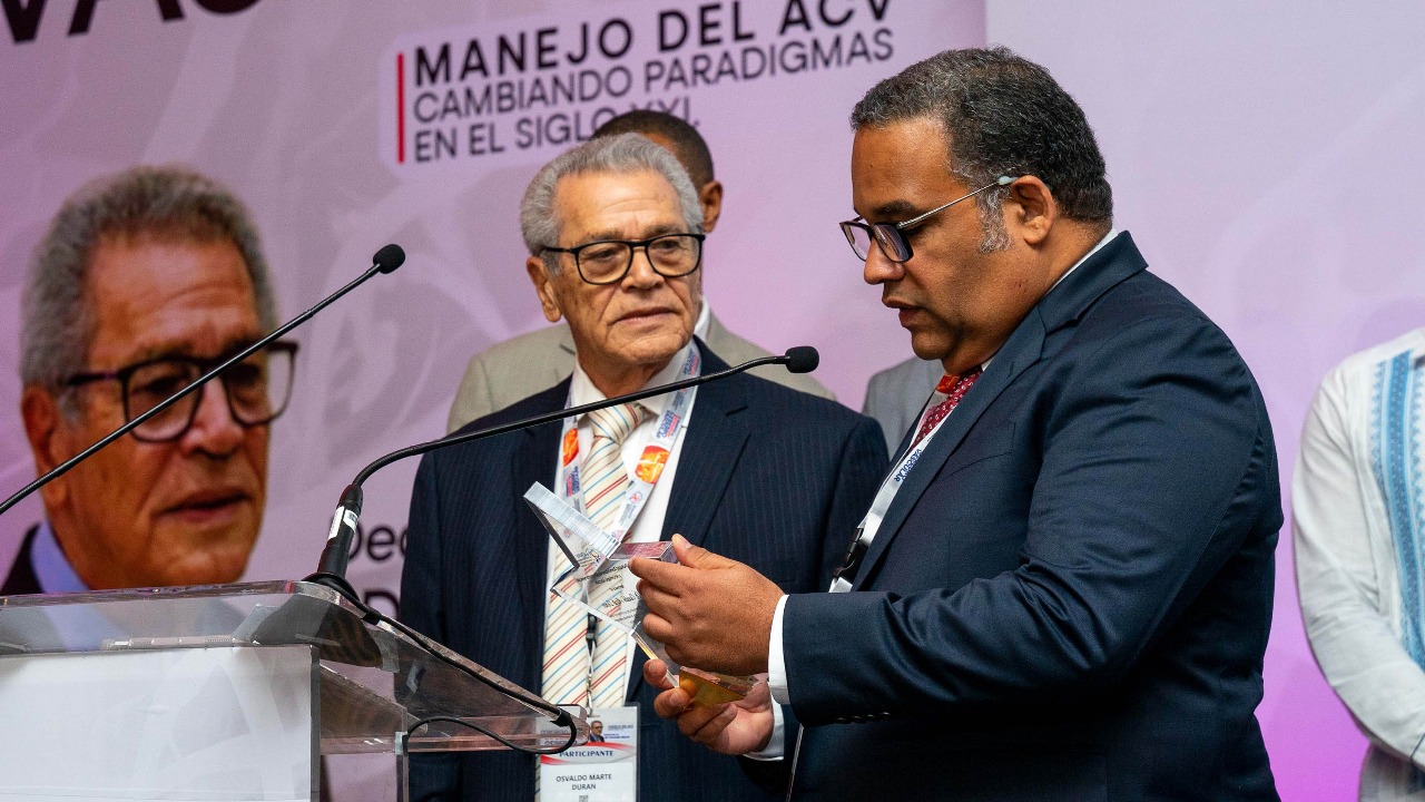 El presidente de la sociedad, Luis Suazo, entrega un reconocimiento a Osvaldo Marté Durán, como leyenda viviente de la neurocirugía dominicana" y fundador de una de las escuelas de neurocirugía más prolíficas del país.